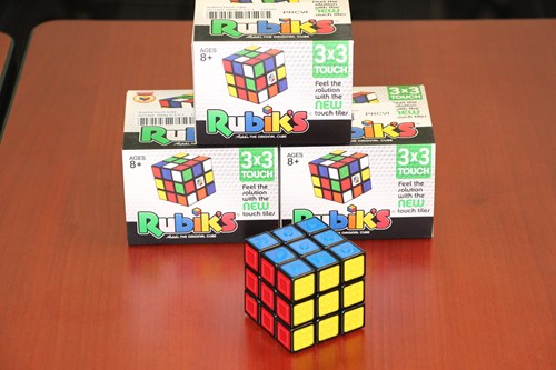 Image shows one Rubik's touch cube in the foreground with three product boxes stacked in the background.