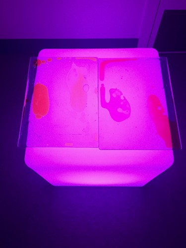 Photo shows the 3D cube lightbox in a darkened room with two APH Swirly Mats placed on top.